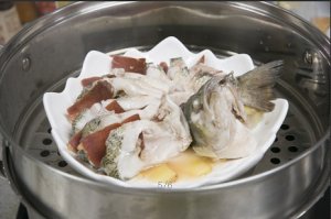 將鱸魚成花狀擺好，將火腿切片放入各縫隙中，放入鍋中隔水蒸12分鐘拿出，撒上蔥花即可。