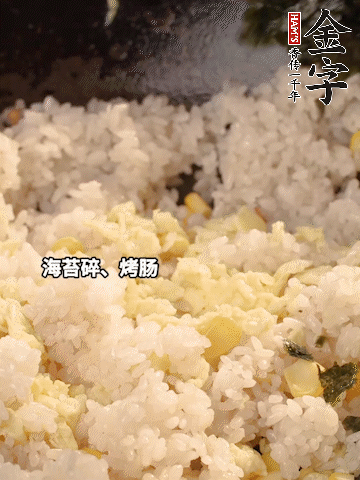 剩米飯下鍋炒散，依次下玉米粒、雞蛋、烤腸、海苔碎翻炒均勻。