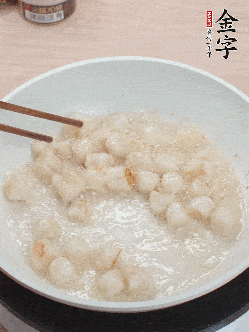 油溫4成熱，鮮貝蘸干淀粉下鍋煎，一面微黃后翻面。
