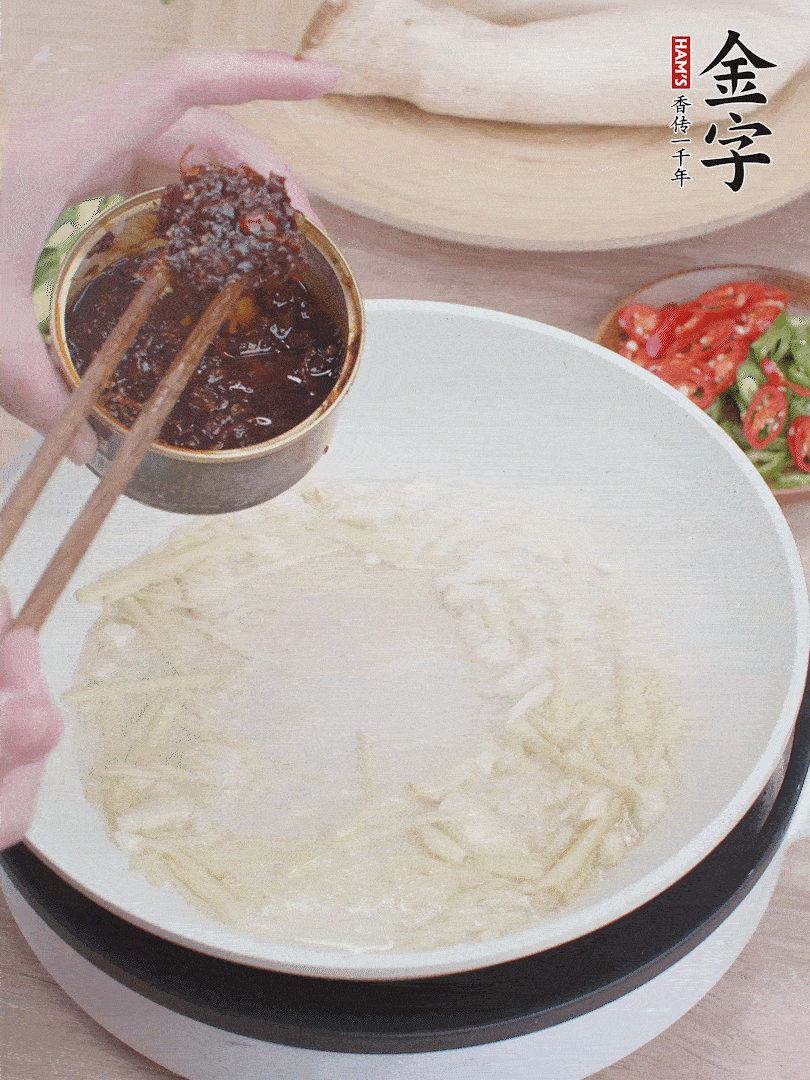 起鍋熱油，姜蒜、金字火腿干貝醬煸香。
