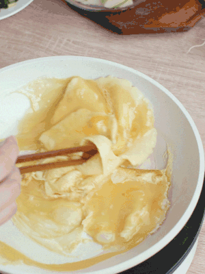 油6成熱時(shí)，下雞蛋液，邊緣凝固時(shí)翻拌成塊狀。