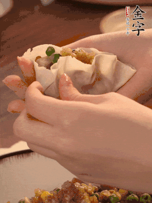 取一大勺餡料放進餃子皮里，用大拇指按住頂部餡料，再用虎口掐出形狀。