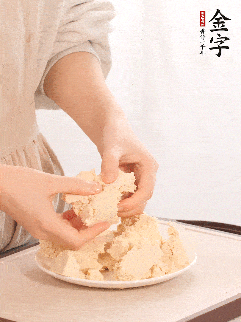 老豆腐用手掰成塊。