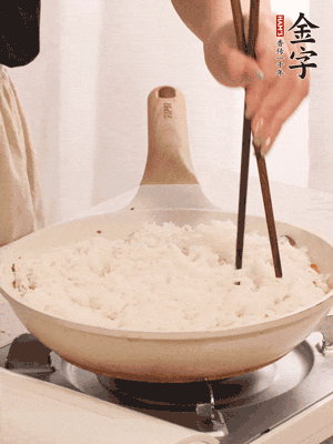 把瀝干水分的米飯均勻鋪在上面，筷子戳幾個洞，以便透氣，轉(zhuǎn)小火蓋上蓋子燜至水分收干，大概10分鐘。
